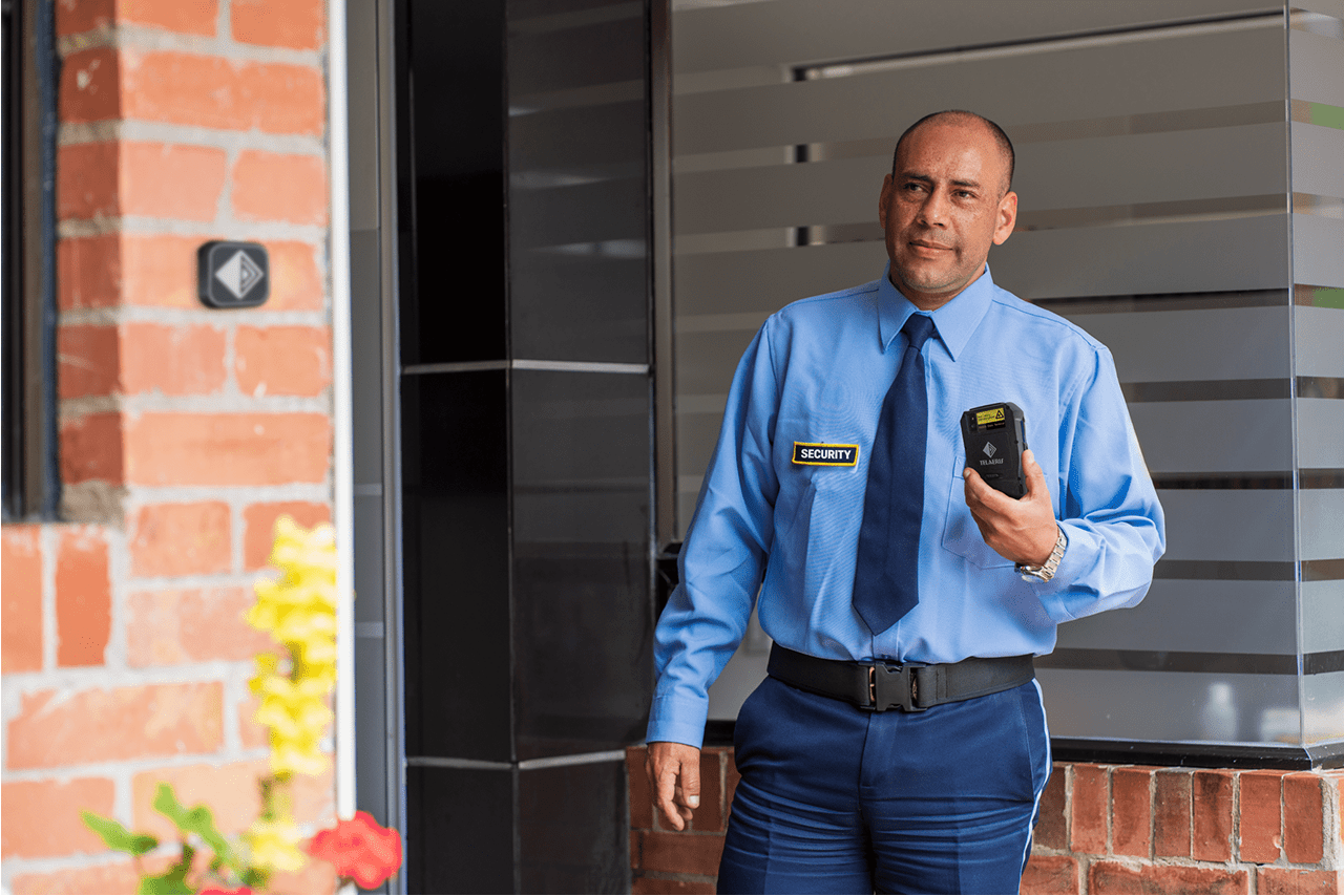 security guard at a building entrance conducting a patrol tour with a telaeris handheld rfid reader